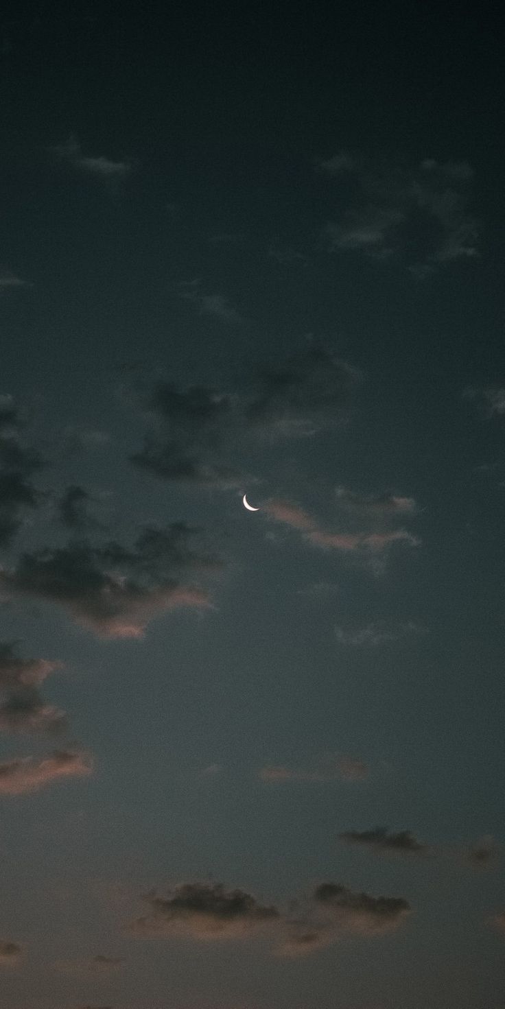 the moon is shining in the sky with clouds