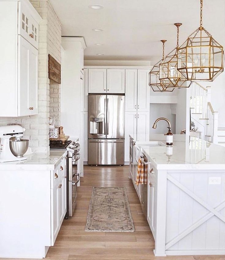 the kitchen is clean and ready for us to use it's white cabinets, stainless steel appliances, and wood floors