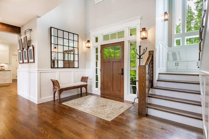 an entryway with wooden floors and white walls