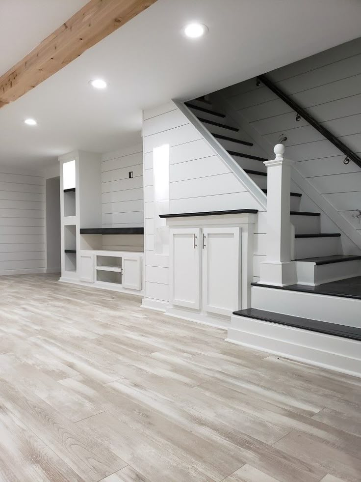 an empty room with white walls and wood floors