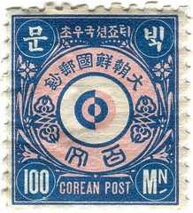 a blue and pink stamp with chinese writing on it's side, in the middle of