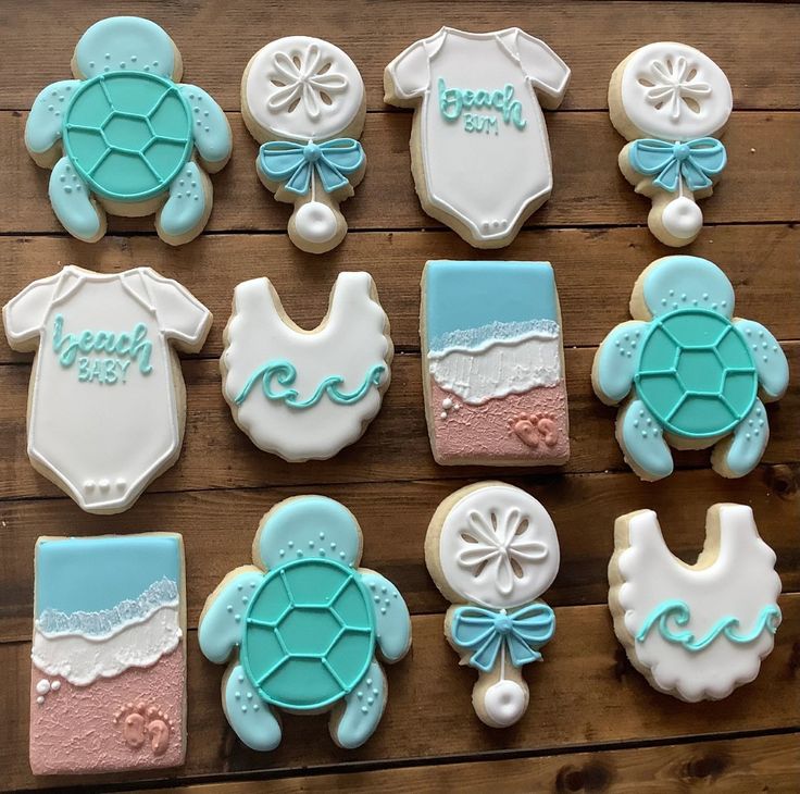 baby shower cookies are arranged on a wooden table