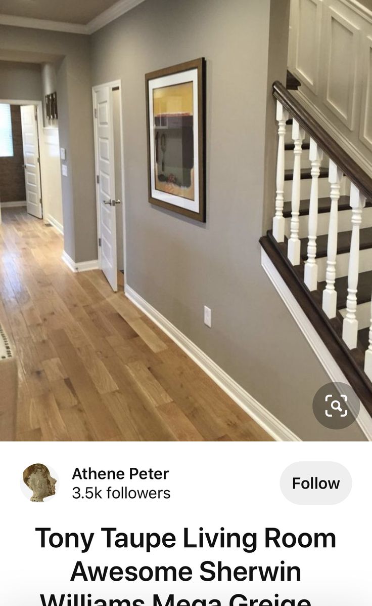 an image of a living room with wood flooring and white railings on the stairs