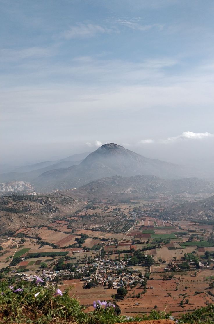 an aerial view of a small town in the distance, with a mountain in the background