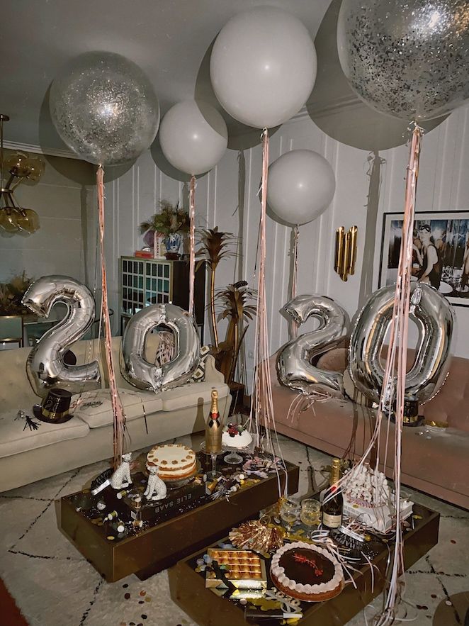 a living room filled with lots of balloons and confetti on top of a table