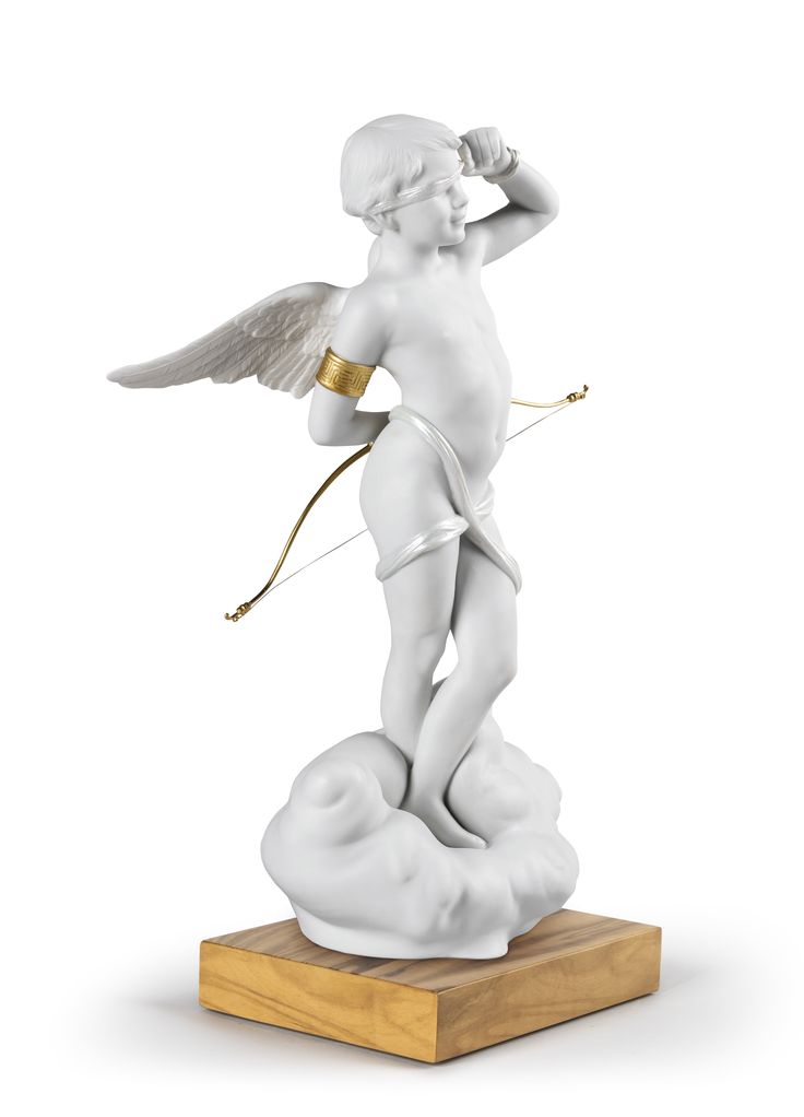 an angel figurine is standing on top of a wooden base and holding a bow