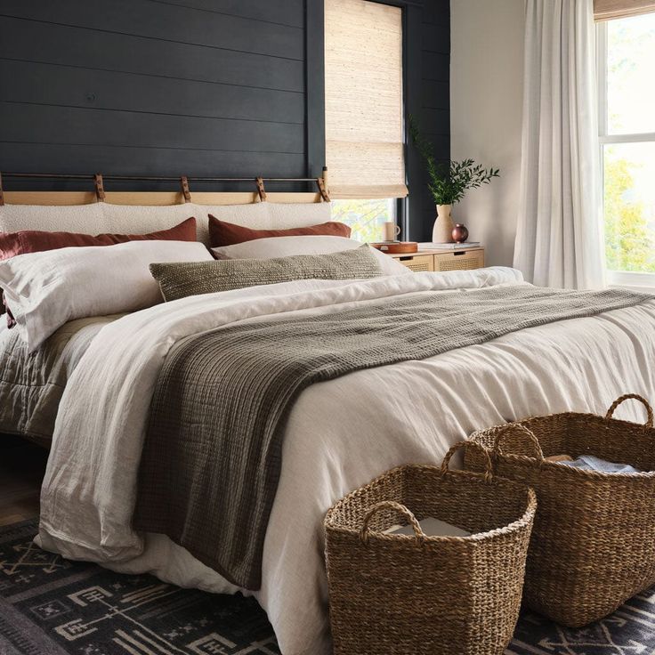 a large bed with two baskets on the floor