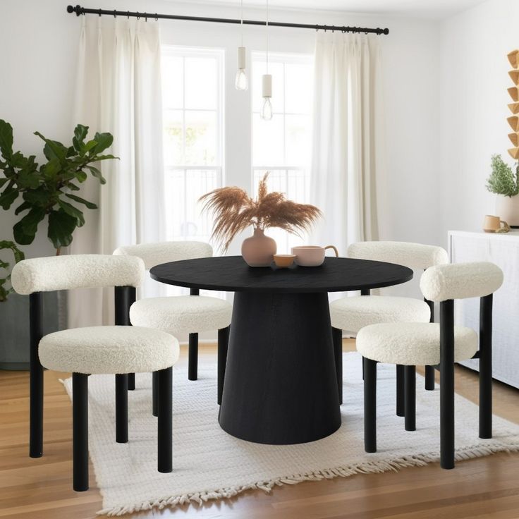 a black table with four white chairs around it