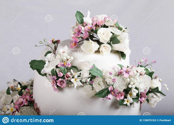 a wedding cake decorated with flowers and greenery on a white background stock photo image