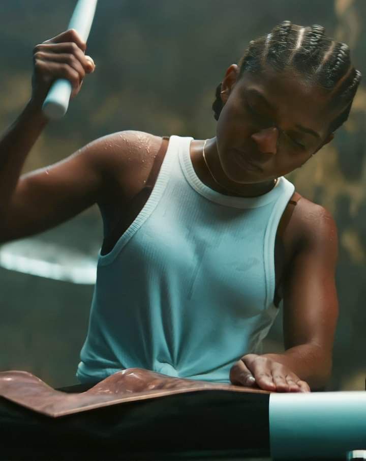 a woman in white shirt holding a knife and cutting something with it's blade