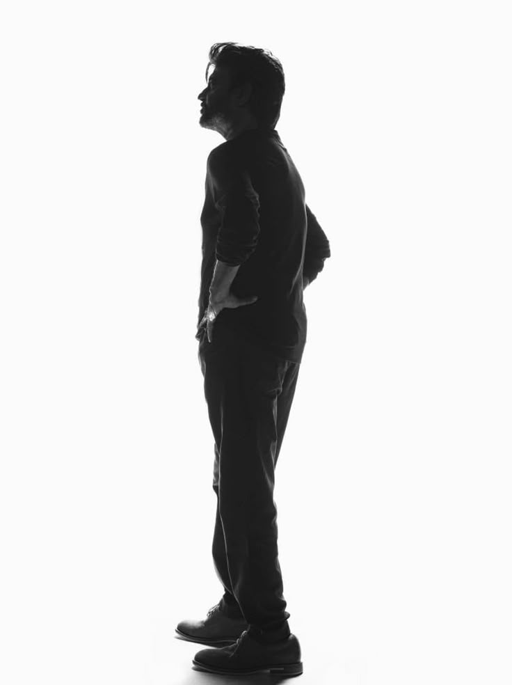 black and white photograph of a man standing with his back to the camera, facing away