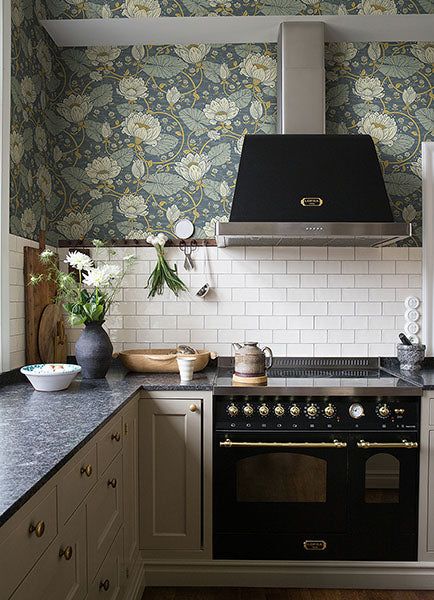 a stove top oven sitting inside of a kitchen next to a wall papered wall