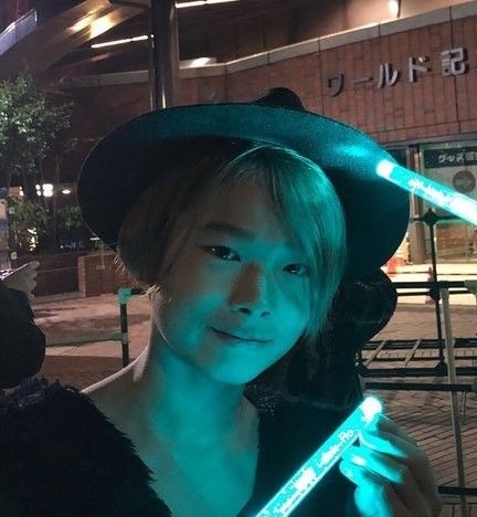 a woman wearing a hat and holding a lit up stick