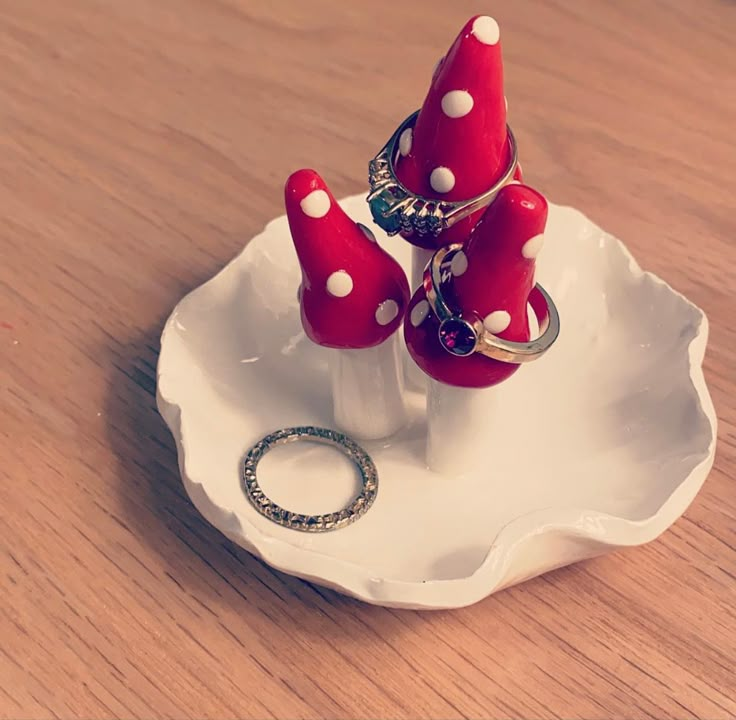 two red and white polka dot rings are on a small plate with a ring holder