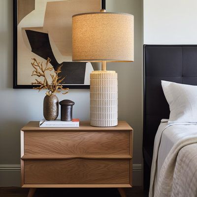 a bedroom with a bed, nightstand and painting on the wall