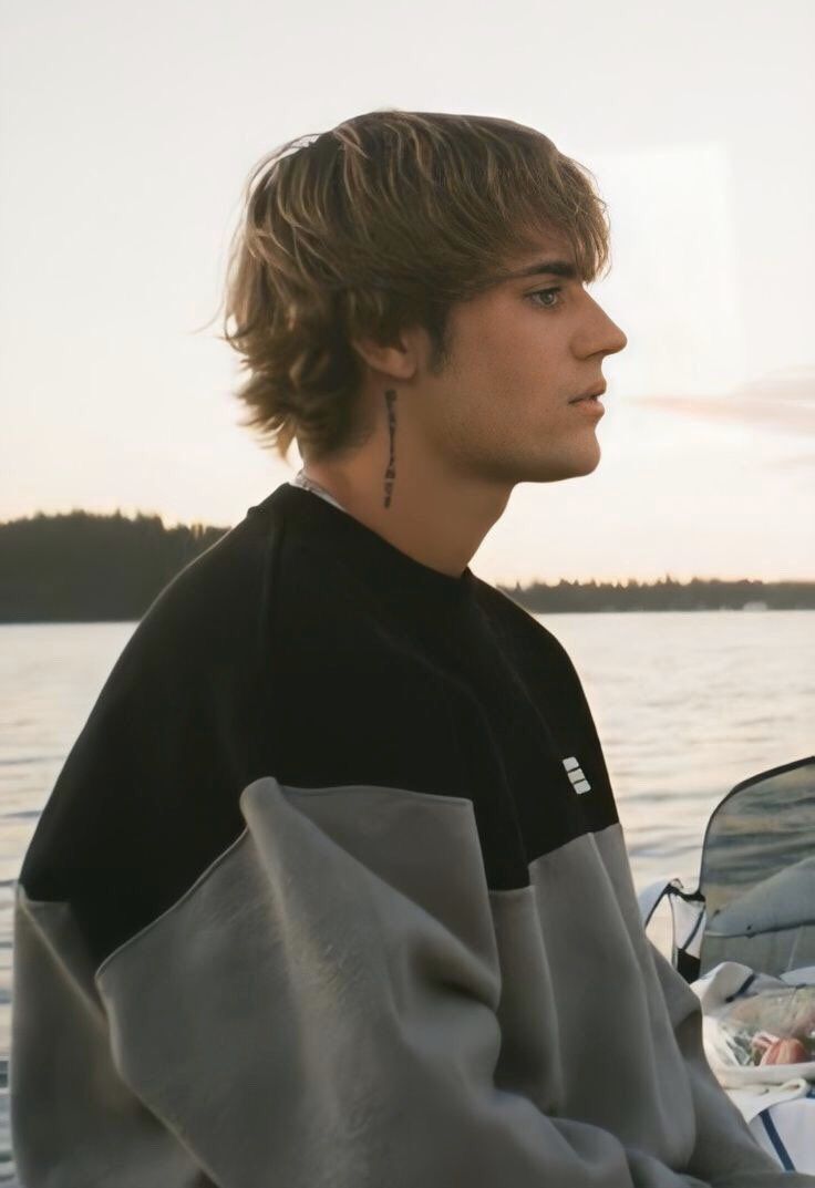 a young man sitting on top of a boat in the water