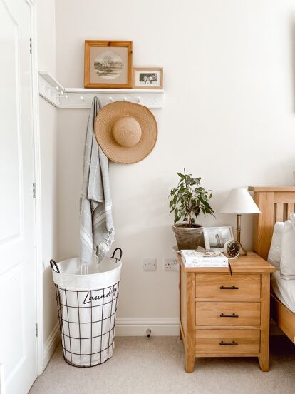 a bedroom with a bed, nightstand and hat hanging on the wall next to it