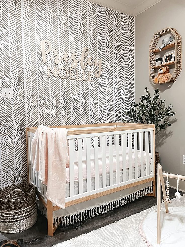 a baby's room with a white crib and grey wallpaper on the walls