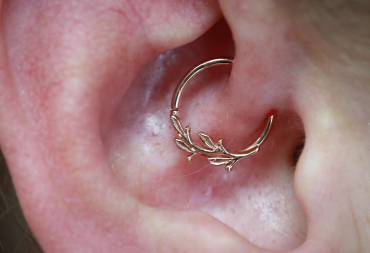 a close up of a person's ear with a ring on top of it