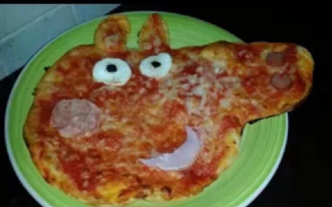 a pizza with googly eyes is on a green plate