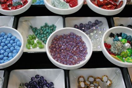 several bowls filled with different types of beads