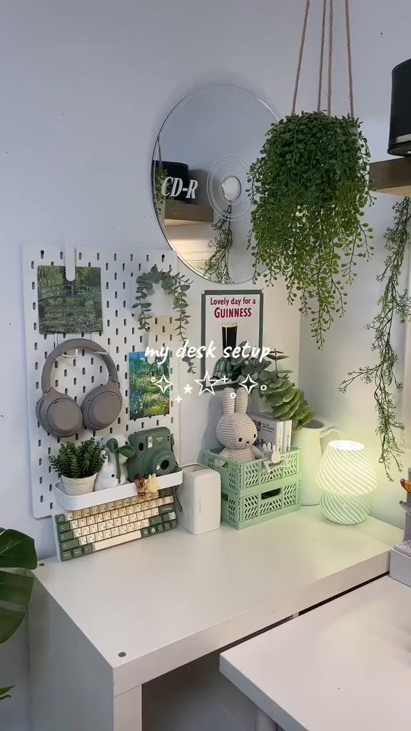 a white desk topped with lots of potted plants next to a wall mounted clock