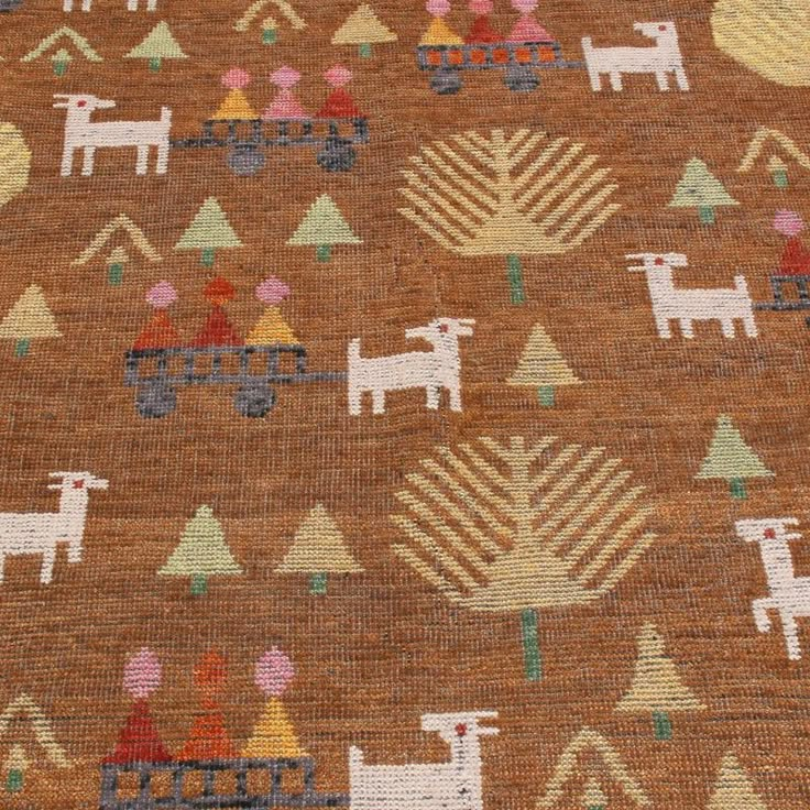 an old rug with animals and trees on the ground in front of a brown background