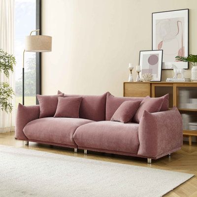 a living room with a pink couch and white rug