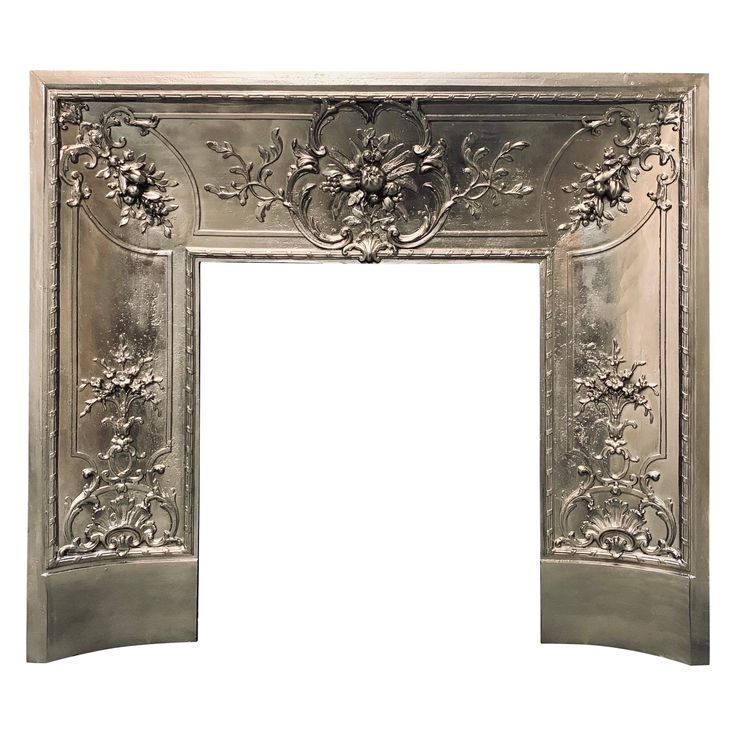 an ornate silver fireplace surround with flowers and leaves