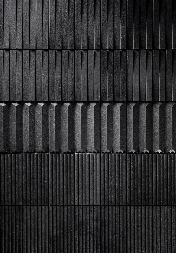 a black and white photo of an abstract wall made up of vertical strips of metal