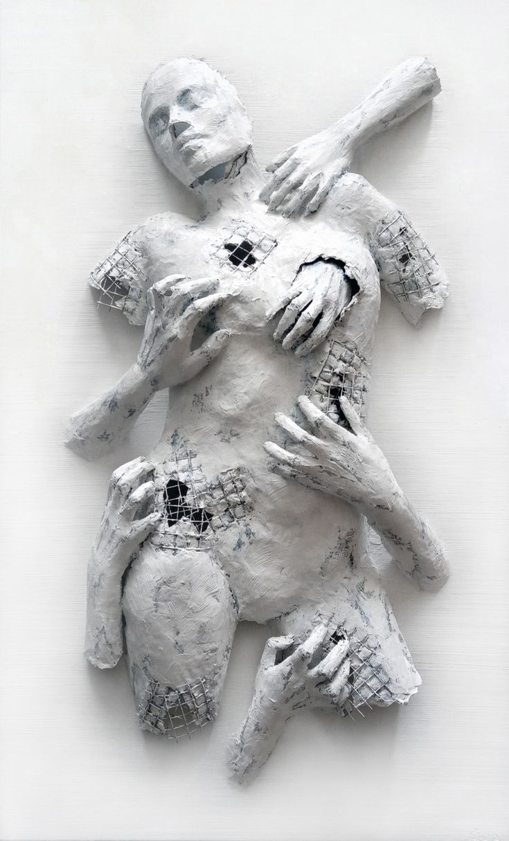 two people hugging each other on top of a white surface