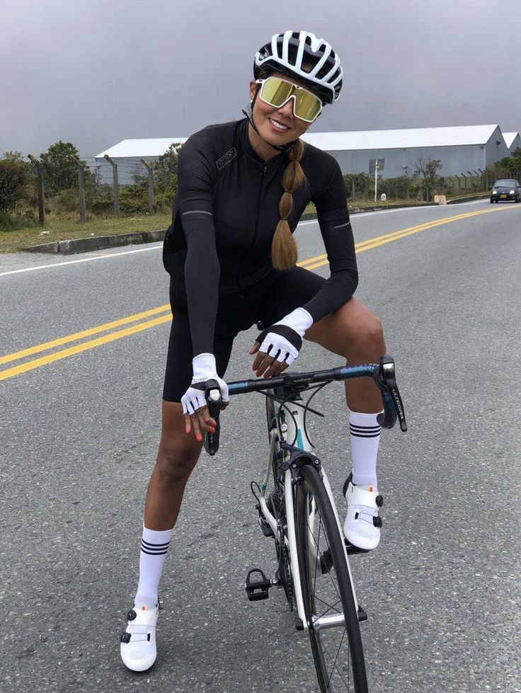 a woman riding a bike down the middle of a road