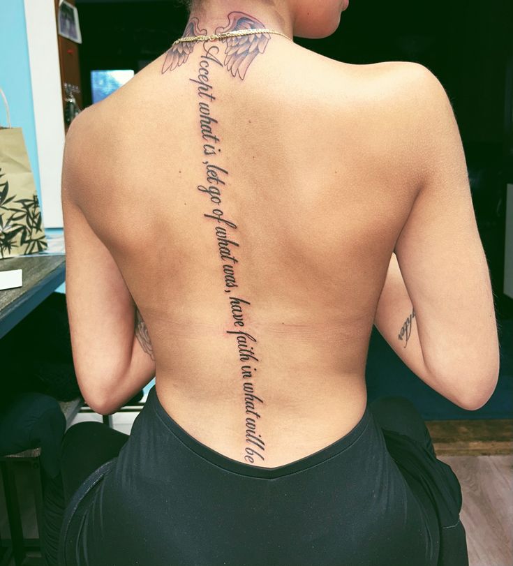 the back of a woman's body with writing on her upper and lower back