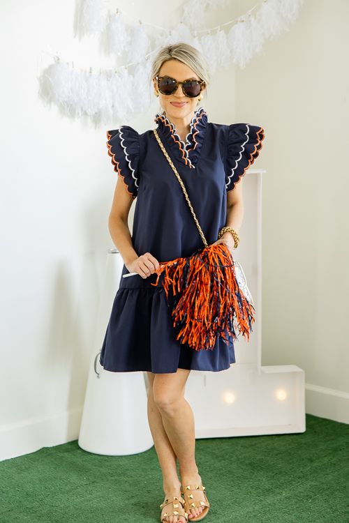 This navy dress is so sweet and preppy. The layered ruffles along the V-neckline and shoulders have a pale blue and orange embroidery trim. The fit falls loosely on the body into a ruffle hem. Preppy Blue Dresses With Ruffles, Preppy Blue Ruffled Dresses, Navy Ruffle Dress For Summer, Navy Mini Dress With Ruffles, Red White And Blue Outfits, College Dress, Auburn Football, Orange Outfit, Navy Dress