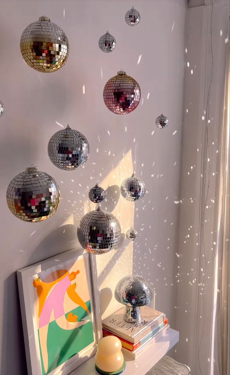 some disco balls are hanging from the ceiling above a small table with a candle on it