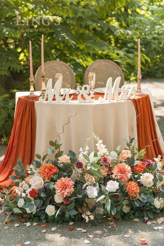 the table is decorated with flowers, candles and mr and mrs signs on top of it