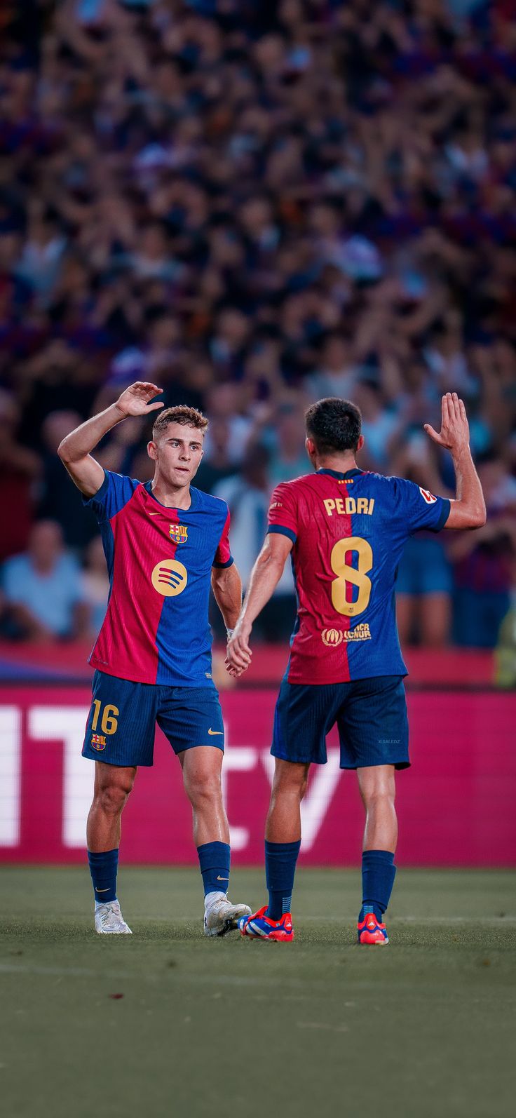 two soccer players standing next to each other on a field