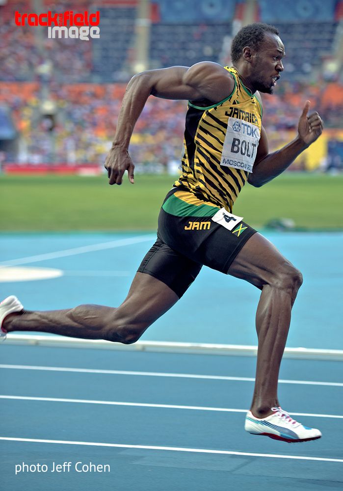 a man running on a track in a stadium