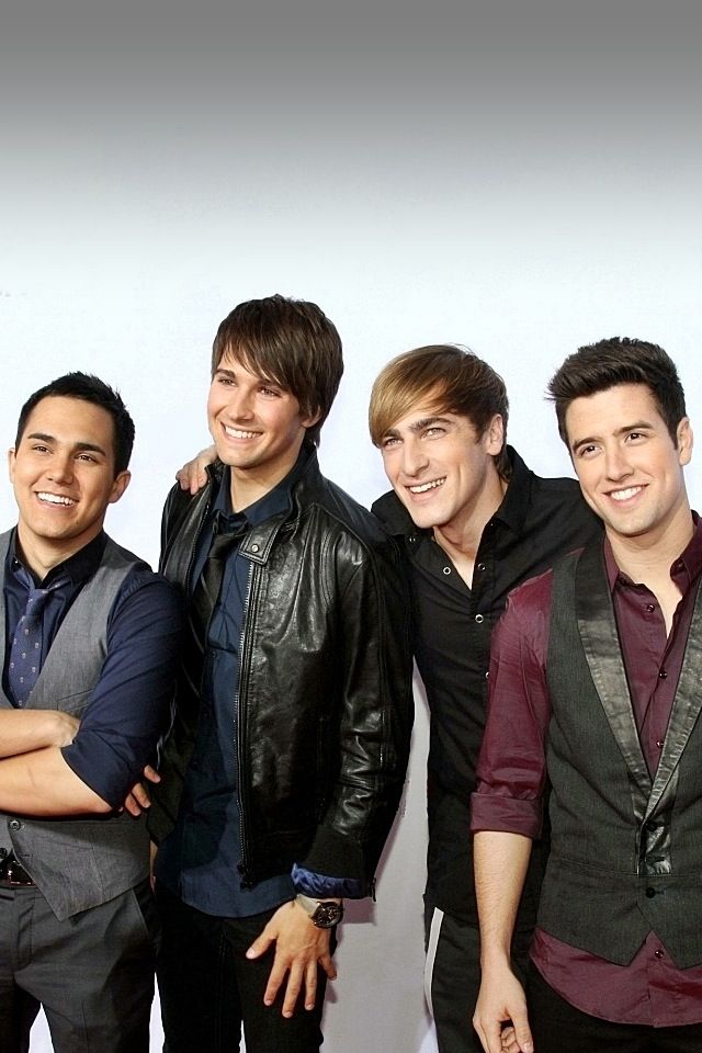 four young men are posing together for a photo in front of a white background and one is wearing a black leather jacket