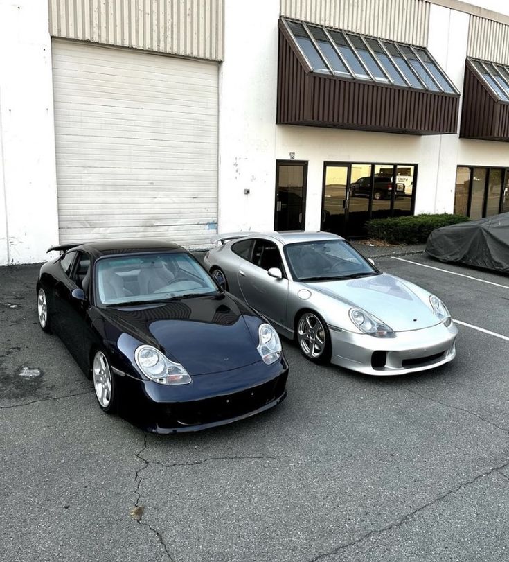 two cars parked next to each other in front of a building