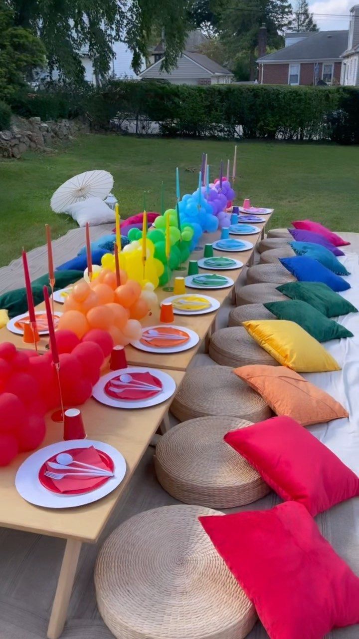 a long table filled with lots of colorful pillows and plates on top of each other