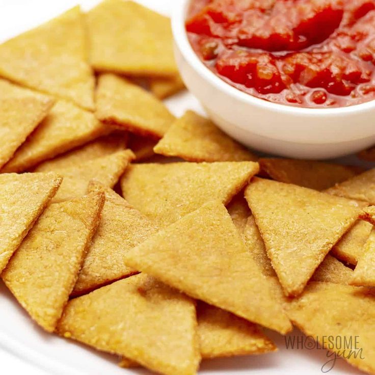 tortilla chips with salsa and ketchup on a white plate, ready to be eaten