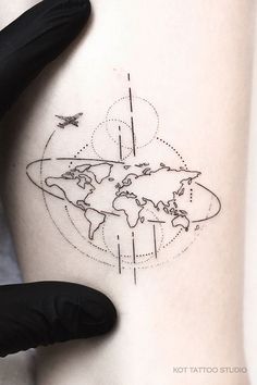 a woman's thigh with a world map tattoo on her left side ribcage