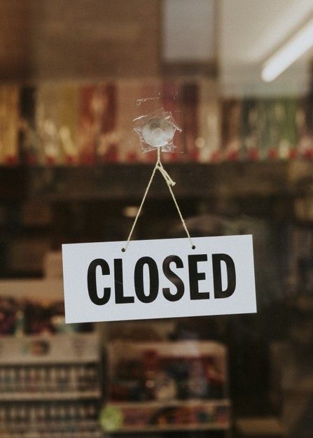 a closed sign hanging from the side of a store window