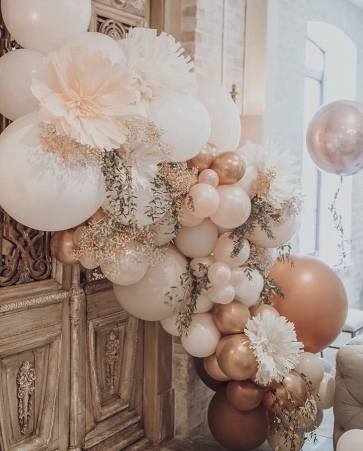 a bunch of balloons that are hanging on a wall in a room with some furniture