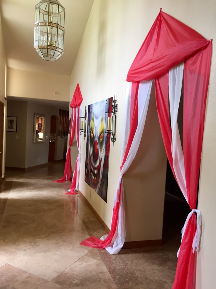 red and white drapes line the hallway leading to an open door with artwork on it