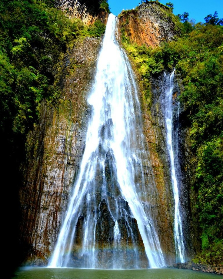 a large waterfall in the middle of a forest