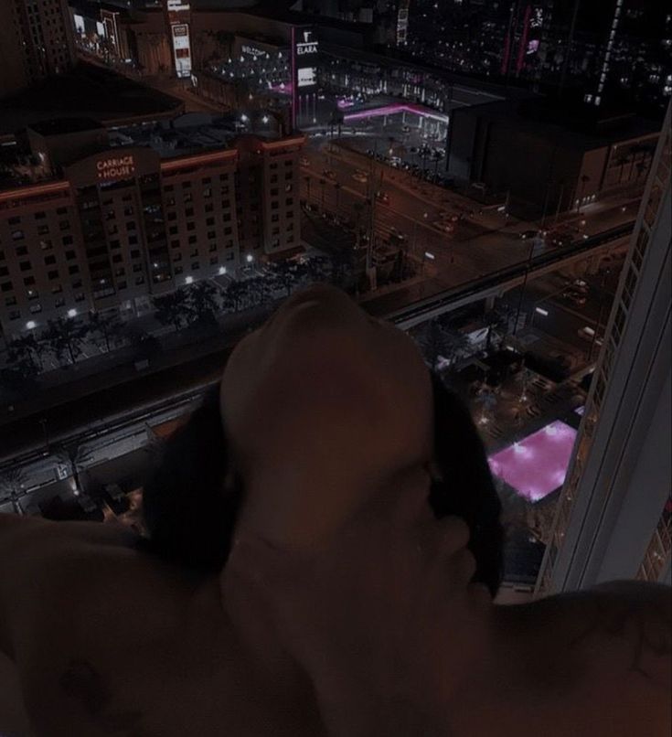 a man is taking a photo from the top of a building at night