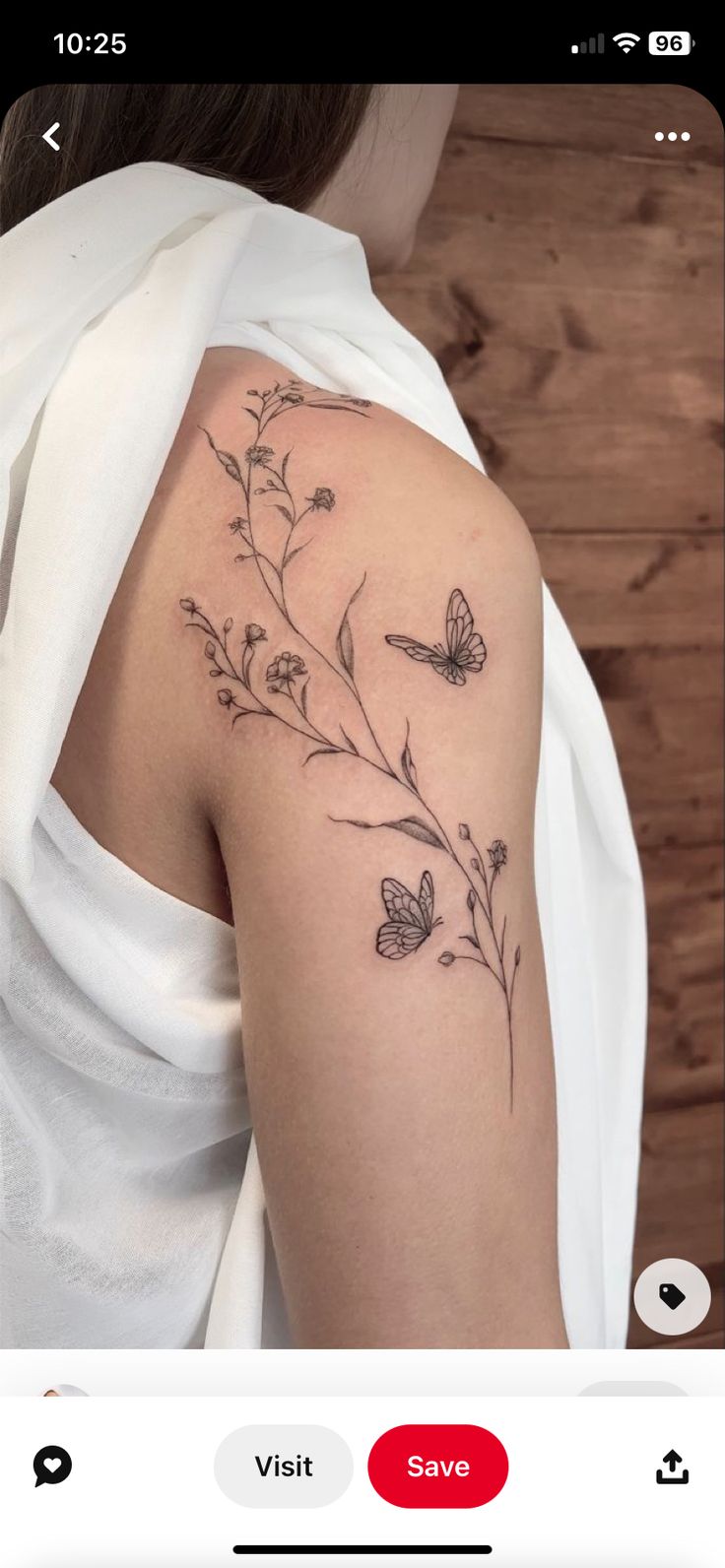 the back of a woman's shoulder with flowers and butterflies on it