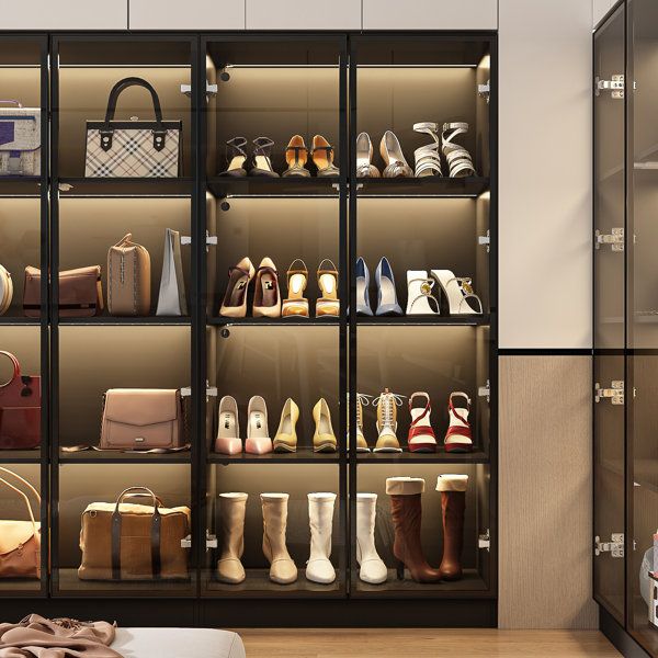 a closet filled with lots of women's shoes and handbags on shelves next to a bed